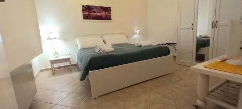 een slaapkamer met een bed met een groene deken bij Miriam Casa Vacanze in Flumini di Quartu