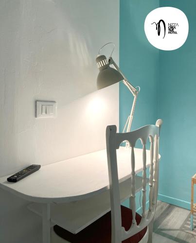 a desk with a lamp and a chair at Hotel Nizza Creative Hotel in Rimini
