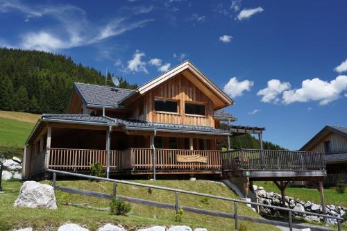 a log home on a hill with a bridge at Luxus Chalet Murmeltierhütte in Hohentauern