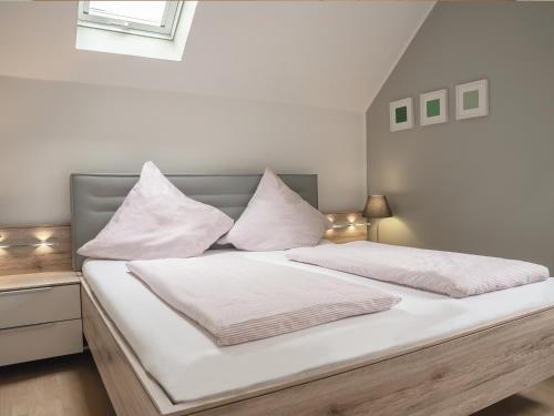 a bed with white sheets and pillows on it at Ferienweingut Lütz in Pünderich