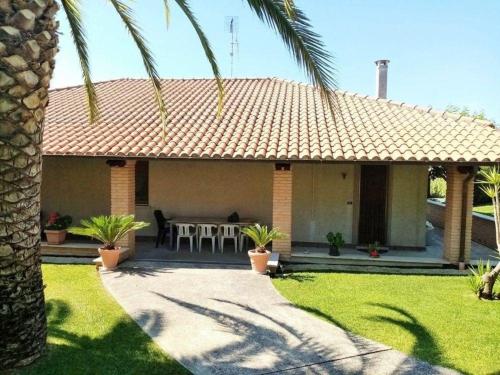 a house with a patio with a table and chairs at Villa fuer 6 Personen mit Schwimmbad in Mosciano SantʼAngelo