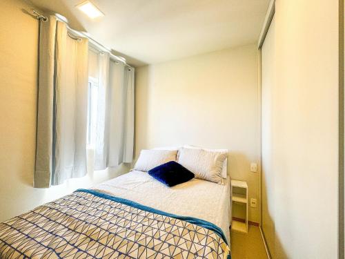 ein kleines Schlafzimmer mit einem Bett mit Fenster in der Unterkunft APTO 1 quarto com Piscina, Metrô in Brasilia