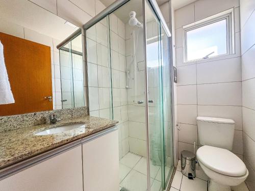 ein Badezimmer mit Toilette und Glasdusche in der Unterkunft APTO 1 quarto com Piscina, Metrô in Brasilia