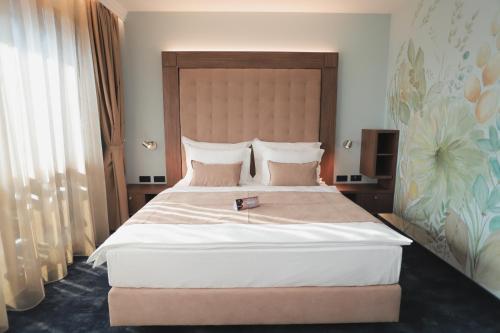 a bedroom with a large bed with a wooden headboard at Hotel Bernarda in Varaždinske Toplice