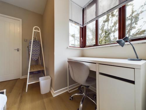 ein Heimbüro mit einem Schreibtisch und einem Fenster in der Unterkunft Cosy Modern Apartment Colchester in Colchester