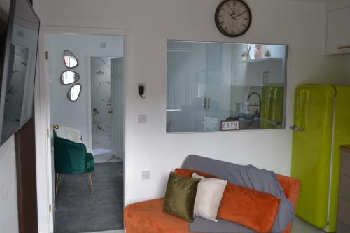 een woonkamer met een bank en een klok aan de muur bij Stylish 1 Bed Apartment 5, free parking 5 mins to CityCentre in Birmingham