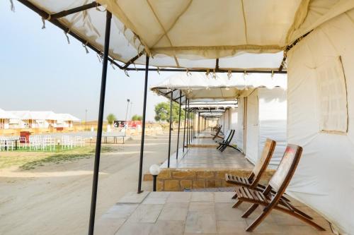 rząd parasoli i krzeseł na patio w obiekcie Collection O Shivas Heritage w mieście Sām