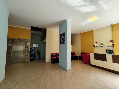 a lobby with yellow walls and red chairs at Апартаменты с видом на горы in Makhinjauri