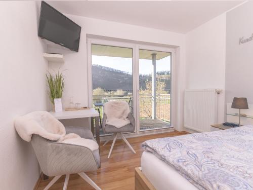 a bedroom with a bed and a desk and a window at Ferienweingut Lütz in Pünderich