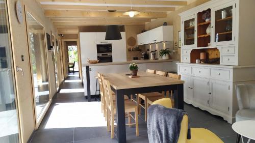 a kitchen with a table and chairs in a room at Gîte Le Charme d'Argent in Charmois-devant-Bruyères