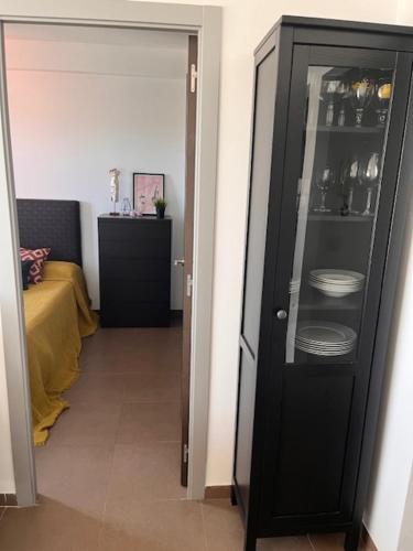 a room with a black cabinet with plates in it at Apartamento con vistas in Roquetas de Mar