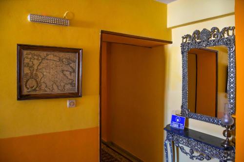 a bathroom with a mirror and a yellow wall at Byron Traditional Hotel in Nafplio
