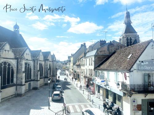 a city street with buildings and a church at Place Sainte Marguerite in Provins