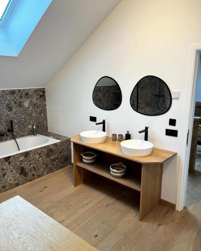 a bathroom with two sinks and a bath tub at Gite Mameye in Tellin