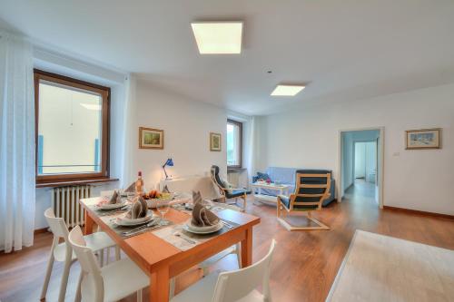 uma sala de estar com uma mesa de jantar e cadeiras em Residenza Rocca Del Lago 4 em Riva del Garda