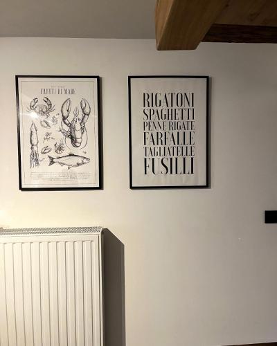 three framed posters on a white wall with a radiator at Gite Mameye in Tellin