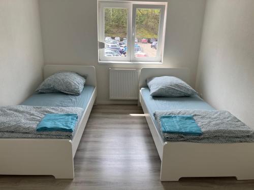 two beds in a room with two windows at L8 Street Monteurwohnung - Mönsheim in Mönsheim