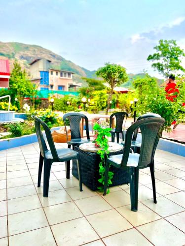 a group of chairs and tables on a patio at Mount View Villa - The Dream Stays ll Pvt Pool ll Garden ll 3Ac rooms in Lonavala