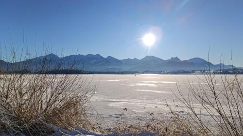 a large body of water with the sun in the sky at Ferienhaus Mayr - Ferienwohnung Bergblick in Füssen