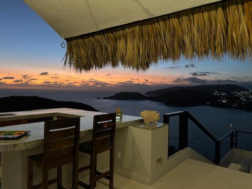 a table with chairs and a view of the ocean at Welcome to the Jungle in Zihuatanejo