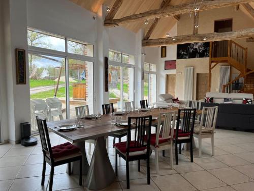 a large dining room with a table and chairs at Gîte Enchanté~ Château~Bain Nordique-Sauna in Chaumont-sur-Tharonne