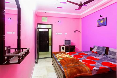 ein rosafarbenes Schlafzimmer mit einem Bett und einem TV in der Unterkunft Hotel Parteek Residency Near Amrabati Park - Bypass Road Digha in Digha