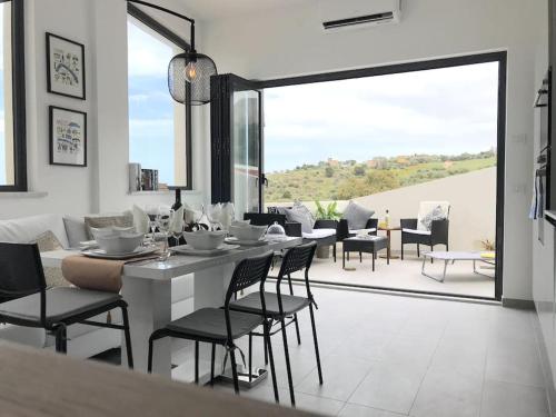 comedor con mesa y sillas y ventana grande en Skyline 360 Estate A secluded retreat stunning sea and mountain views, en Caccamo