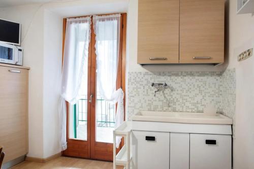 a kitchen with a sink and a large window at Casa Miky in Lanzada