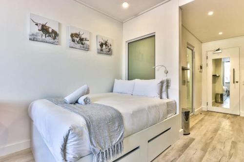 a white bedroom with a bed and a window at 317 Alberts in Cape Town