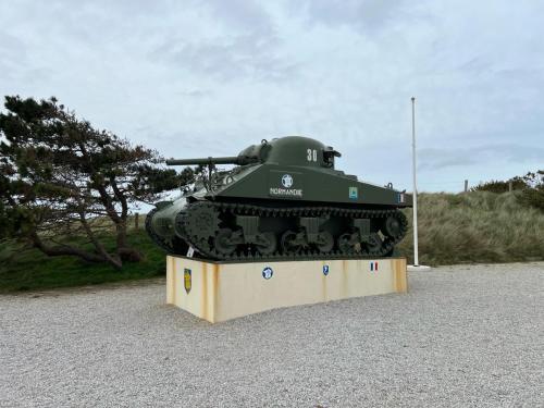 a green tank on display in a parking lot at Appartement Brise Marine in Grandcamp-Maisy