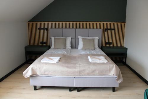 a bedroom with a large bed with two pillows at Biała Woda in Suwałki