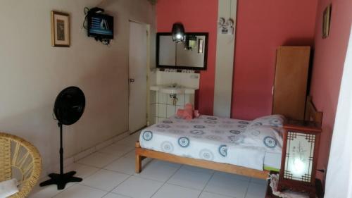 a small bedroom with a bed and a mirror at Punta Pacífico Bungalows Máncora in Máncora