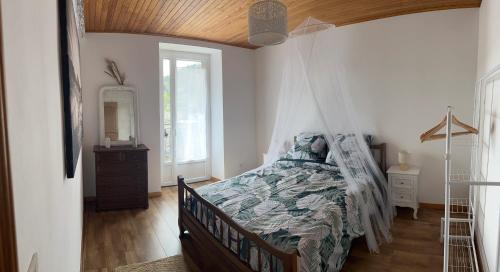 une chambre avec un lit à baldaquin dans l'établissement L’Hacienda, maison de caractère, à Saint-Martin-de-Valamas