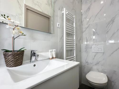 biała łazienka z umywalką i toaletą w obiekcie 2063 - Orsay studio in Paris Olympic Games 2024 w Paryżu