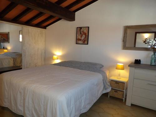 - une chambre avec un lit blanc et deux lampes dans l'établissement Belle villa T3 avec terrasse proche de la plage de St Cyprien, à Saint-Cyprien