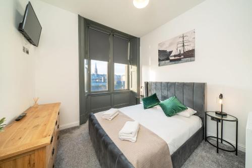 a bedroom with a large bed and a television at Dockside in Dundee
