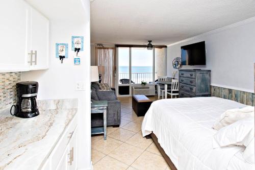 ein Schlafzimmer mit einem Bett und ein Wohnzimmer in der Unterkunft Pirates Cove Condo Unit #407 in Daytona Beach