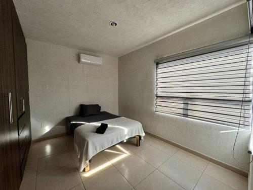 a bedroom with a bed and a window with lights at Casa en Fraccionamiento Privado in Lázaro Cárdenas