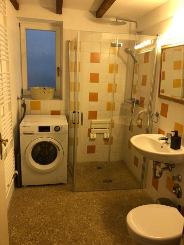 ein Badezimmer mit einer Waschmaschine und einem Waschbecken in der Unterkunft Fachwerkhaus Hartmann in Bad Münder am Deister
