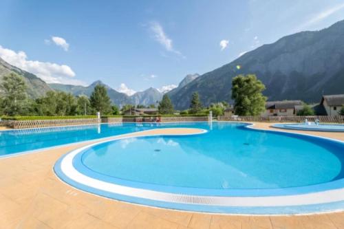 uma grande piscina com montanhas ao fundo em Chalet 4 étoiles - eeeaeh em Le Bourg-dʼOisans