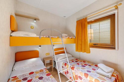 1 Schlafzimmer mit 2 Etagenbetten und einem Fenster in der Unterkunft Pian Dei Boschi - Superior 8 in Pietra Ligure