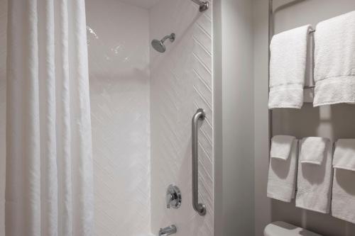 y baño con ducha, aseo y toallas. en TownePlace Suites Chicago Lombard, en Lombard