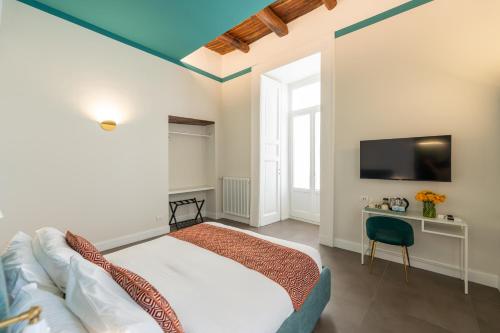 um quarto com uma cama e uma televisão na parede em Pignasuite em Nápoles