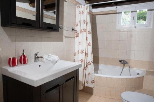 a bathroom with a sink and a bath tub at Emerald Heaven in Panteli