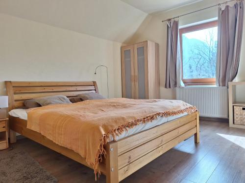 a bedroom with a wooden bed and a window at Adventure House in Palfau