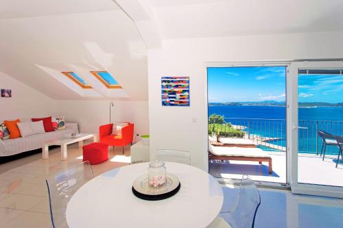 een woonkamer met een witte tafel en uitzicht op de oceaan bij Blue Bay Residence in Hvar