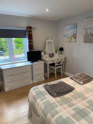 a bedroom with two beds and a desk with a computer at Beach Cottage in Berwick-Upon-Tweed