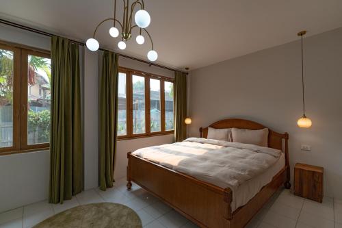 a bedroom with a bed in a room with windows at 清迈古城柚子别墅塔佩门里 in Chiang Mai