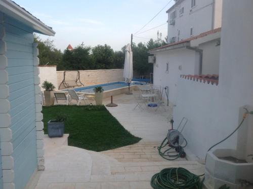 a backyard with a swimming pool and a patio at Apartments Little Castle in Vodice