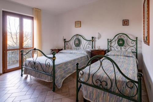 a bedroom with two beds and a window at Relais Parco Del Subasio in Piano Delle Pieve